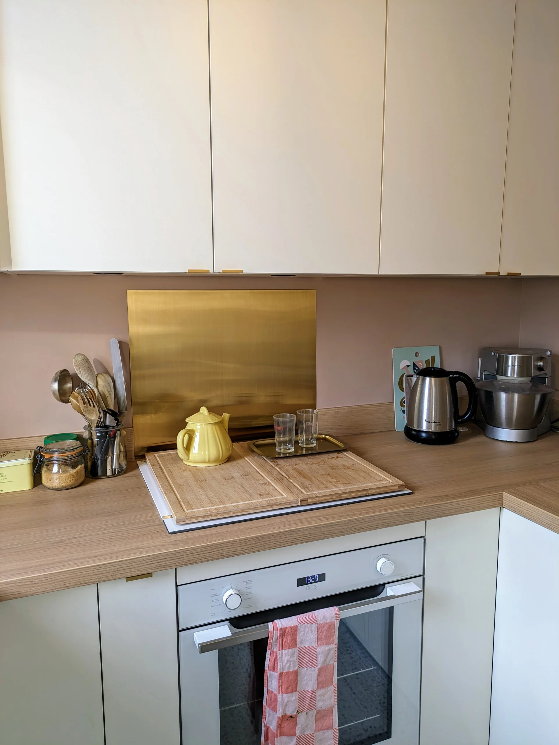 Vue détaillée de la cuisine rénovée avec du terrazzo, des façades blanc cassé, et des touches de rose nude. Un projet sur-mesure d’aménagement intérieur. Cuisine sur-mesure avec de, la, cuisine, four, meuble, blanc, rénovation contemporaine