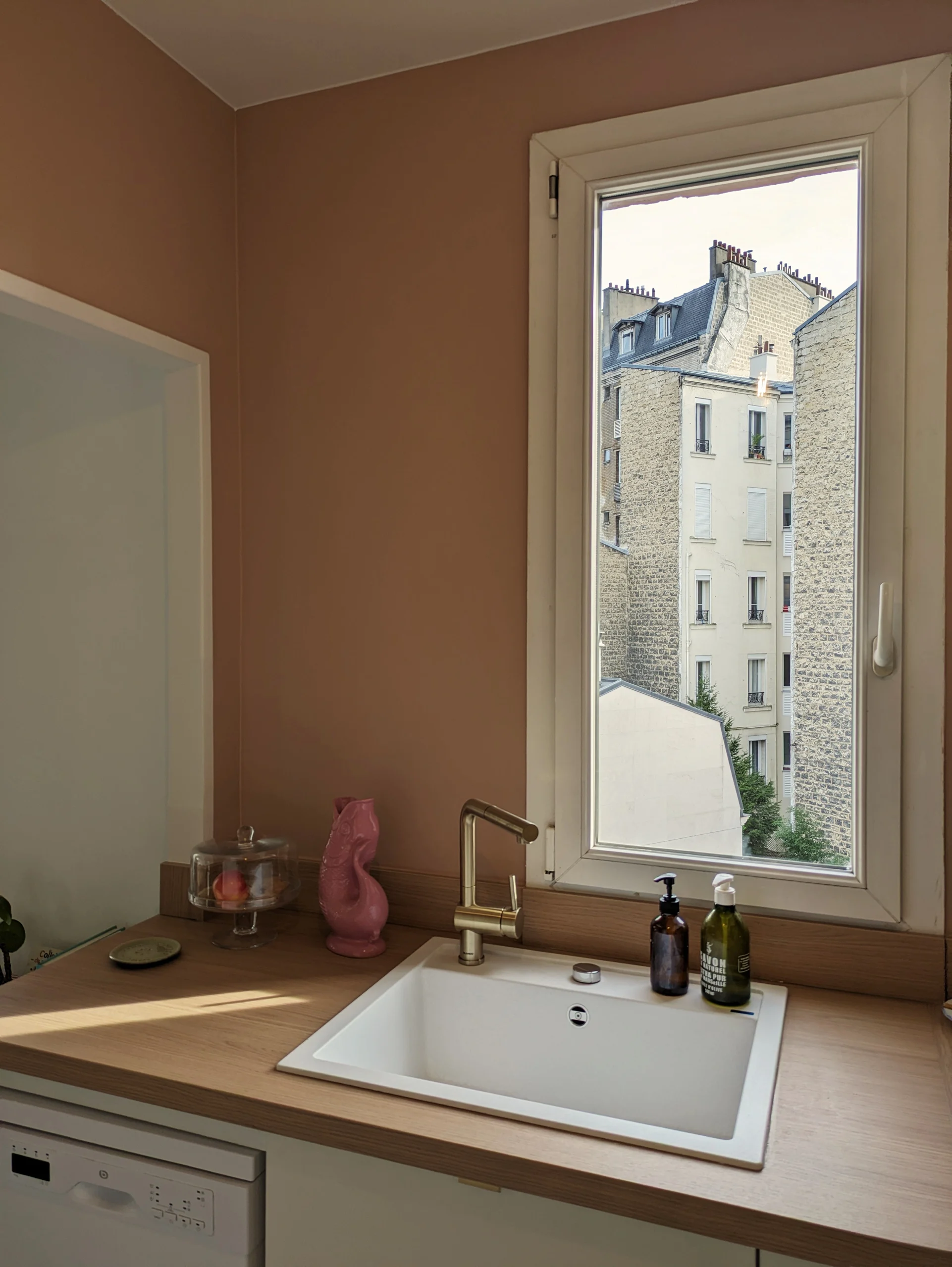 Vue détaillée de la cuisine rénovée avec du terrazzo, des façades blanc cassé, et des touches de rose nude. Un projet sur-mesure d’aménagement intérieur. Cuisine sur-mesure avec de, côté, de, l'évier, blanco, silgranit, rénovation contemporaine