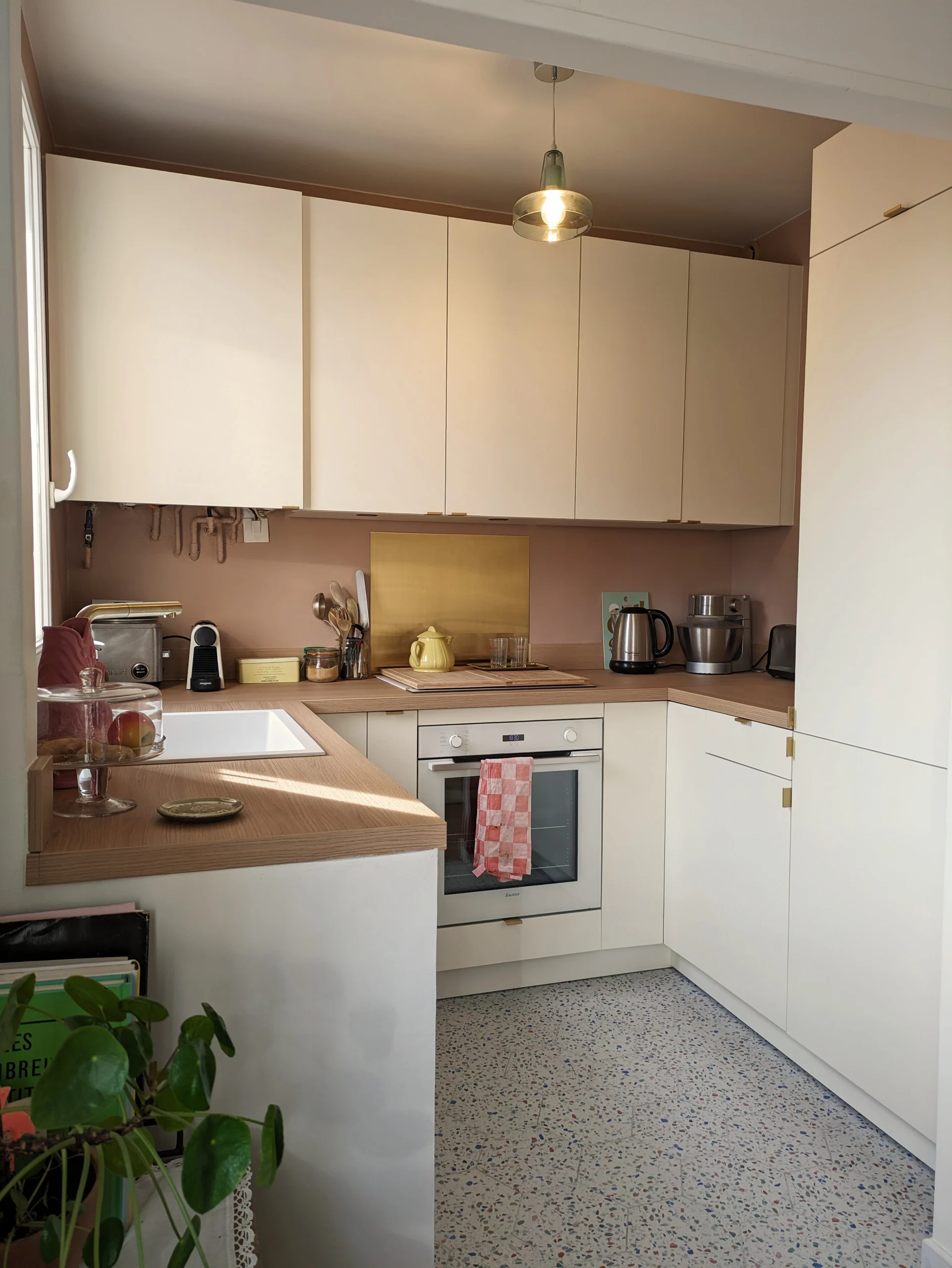 Vue détaillée de la cuisine rénovée avec du terrazzo, des façades blanc cassé, et des touches de rose nude. Un projet sur-mesure d’aménagement intérieur. Cuisine sur-mesure avec cuisine, sur, mesure, beige, bois, renovation, rénovation contemporaine