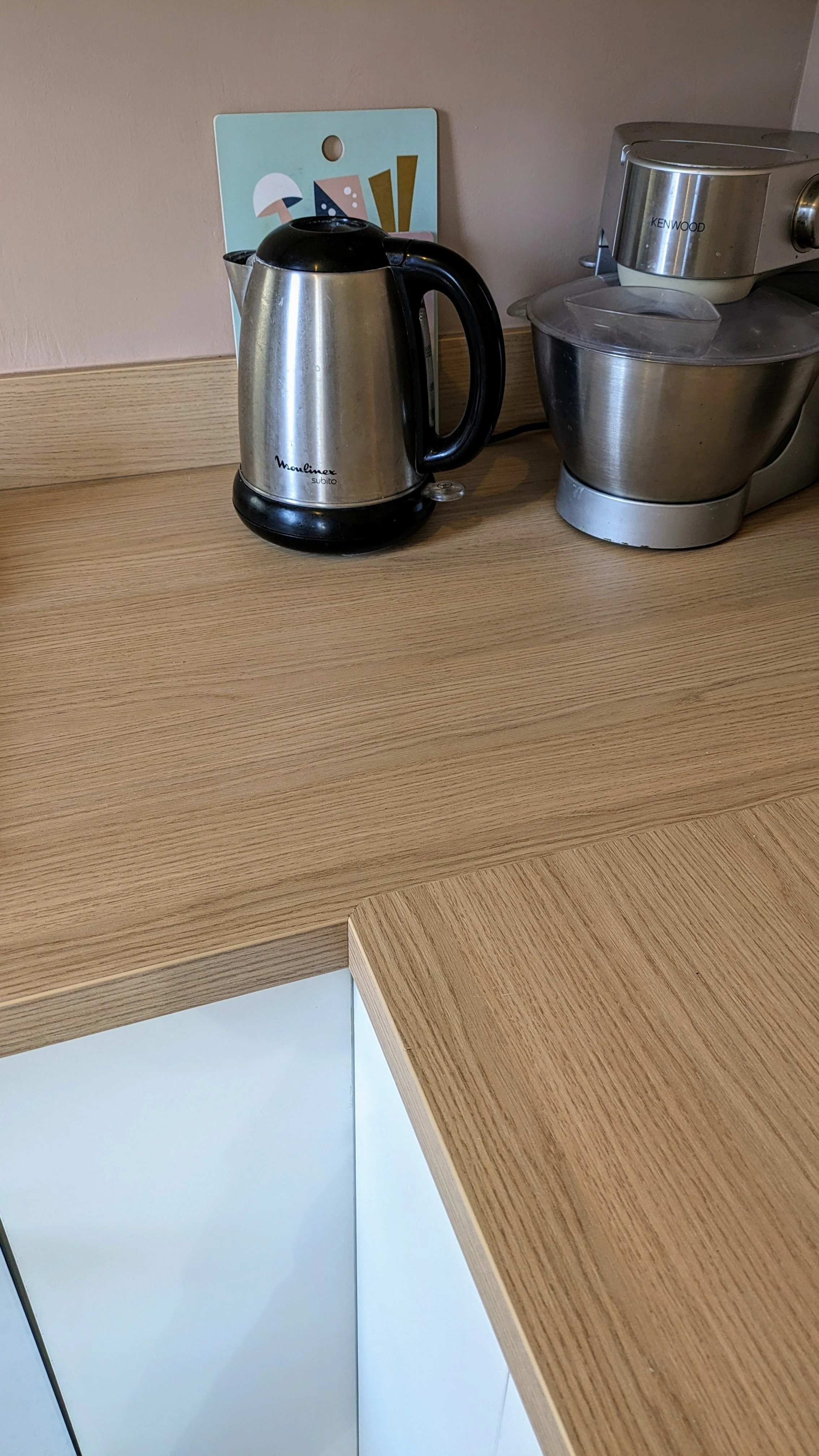 Vue détaillée de la cuisine rénovée avec du terrazzo, des façades blanc cassé, et des touches de rose nude. Un projet sur-mesure d’aménagement intérieur. Cuisine sur-mesure avec sur, l'angle, du, plan, de, travail, rénovation contemporaine