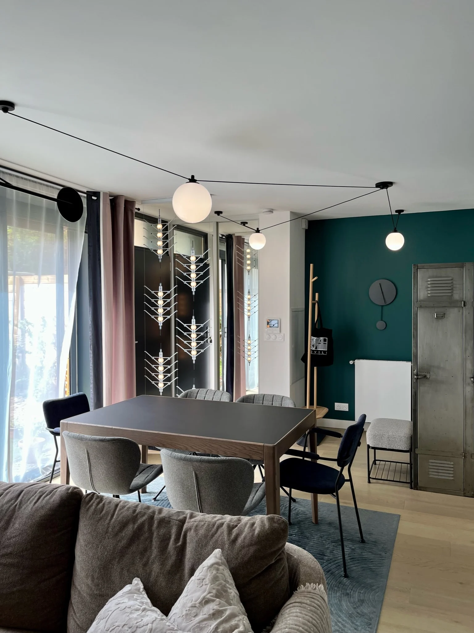 Salle à manger et entrée mises en lumière par la suspension Gras Salle à manger, entrée et suspension Les Acrobates n°325 Gras